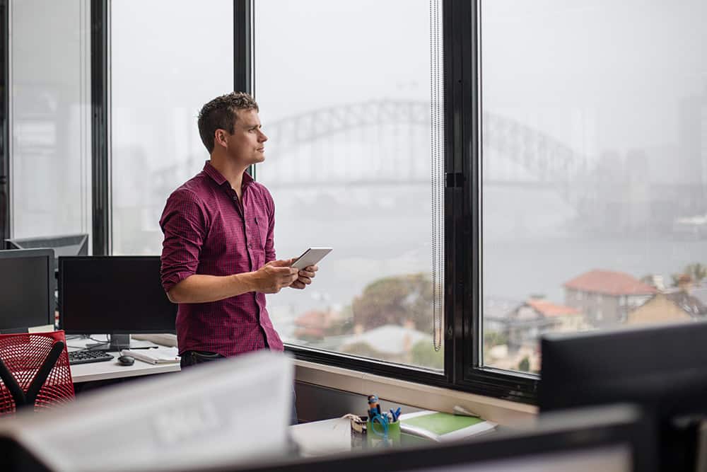 A Professional Gazing Out Of An Office Window